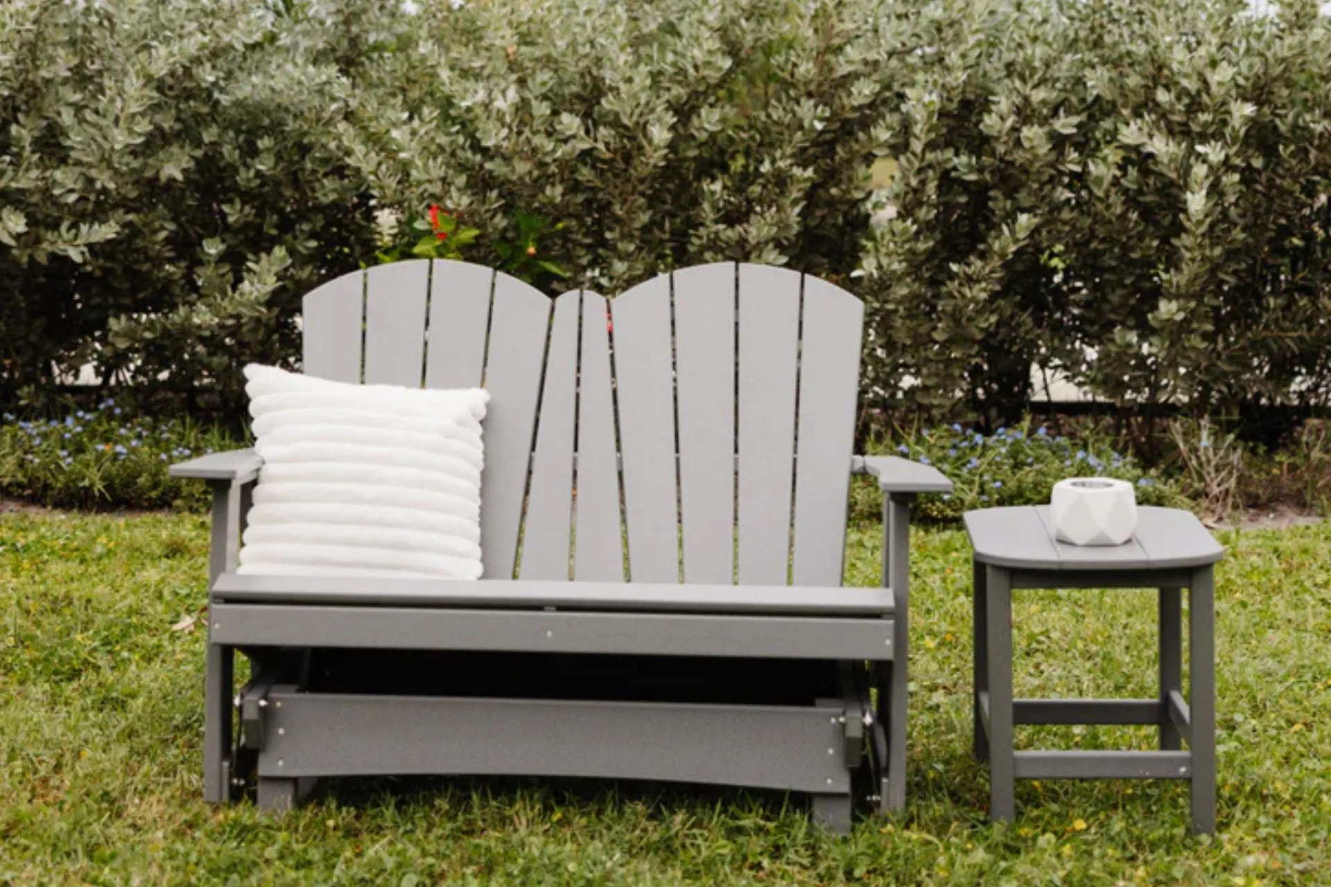 An outdoor chair and stands sitting in backyard.