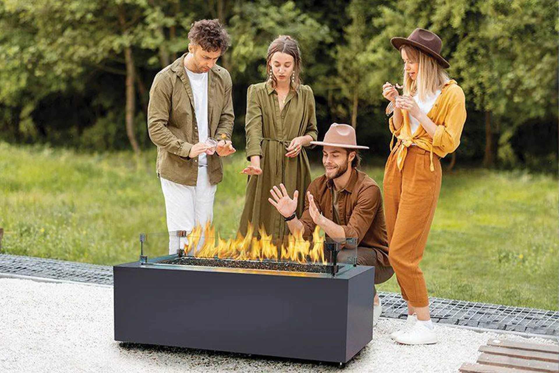 4 people standing next to a fire pit outside in their backyard.
