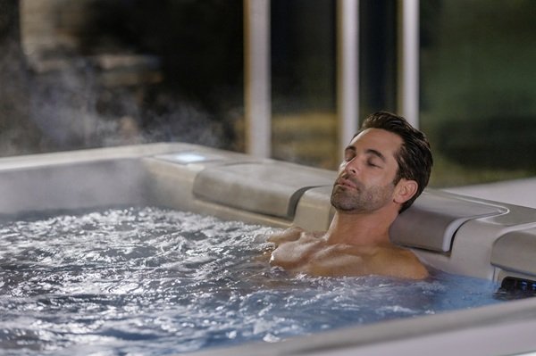 A man sitting in a hot tub and relaxing in the water.